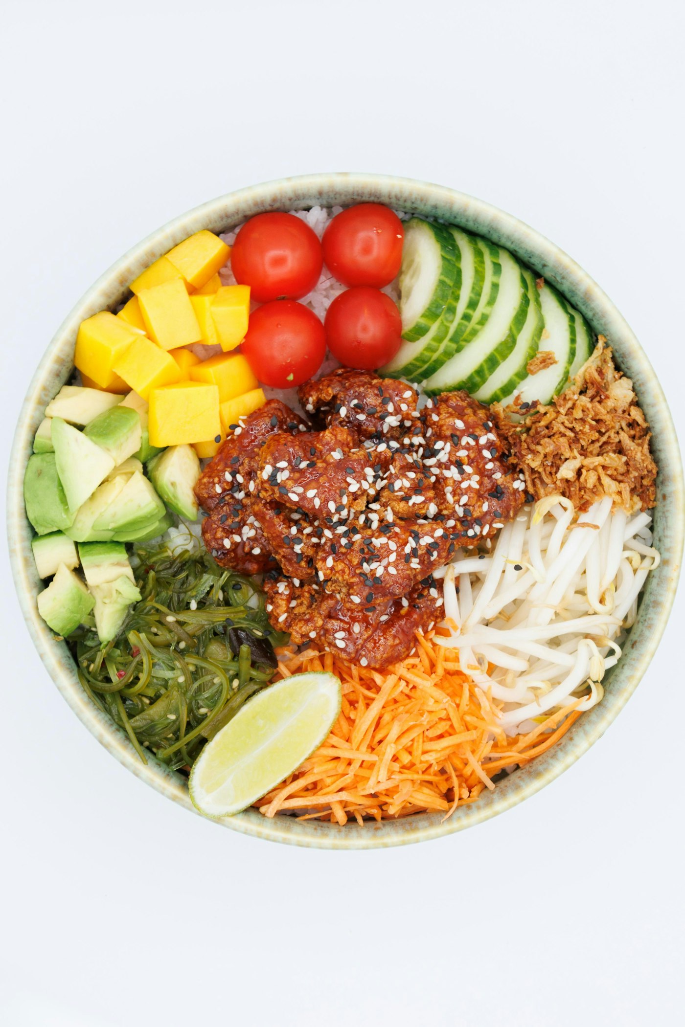 치킨과 망고, 방울토마토, 오이, 아보카도, 당근채를 올린 컬러풀한 포케볼 톱다운 컷