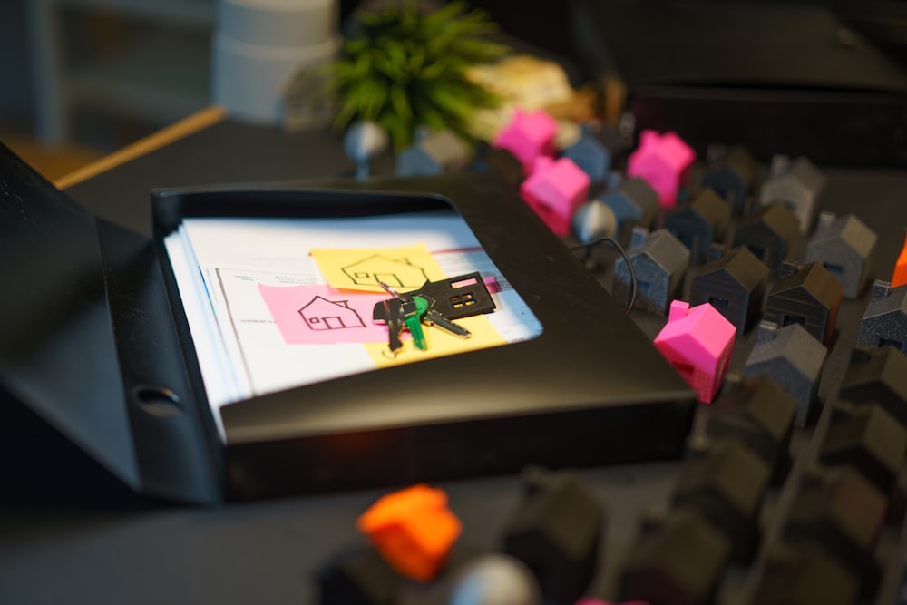 A property folder with house keys and miniature model homes, representing catastrophe bond and insurance renewal paperwork