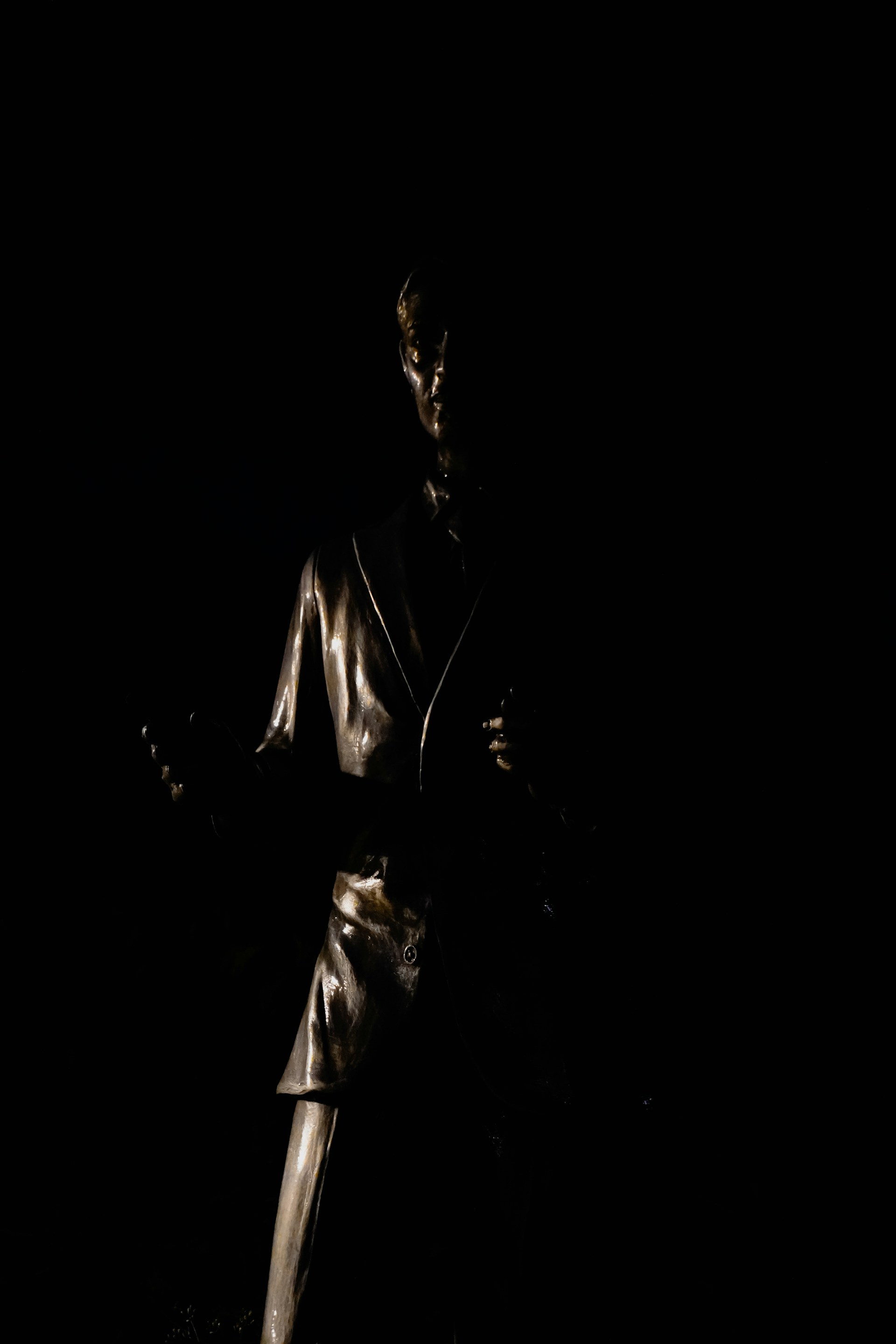 A metallic statue of a woman in a suit.