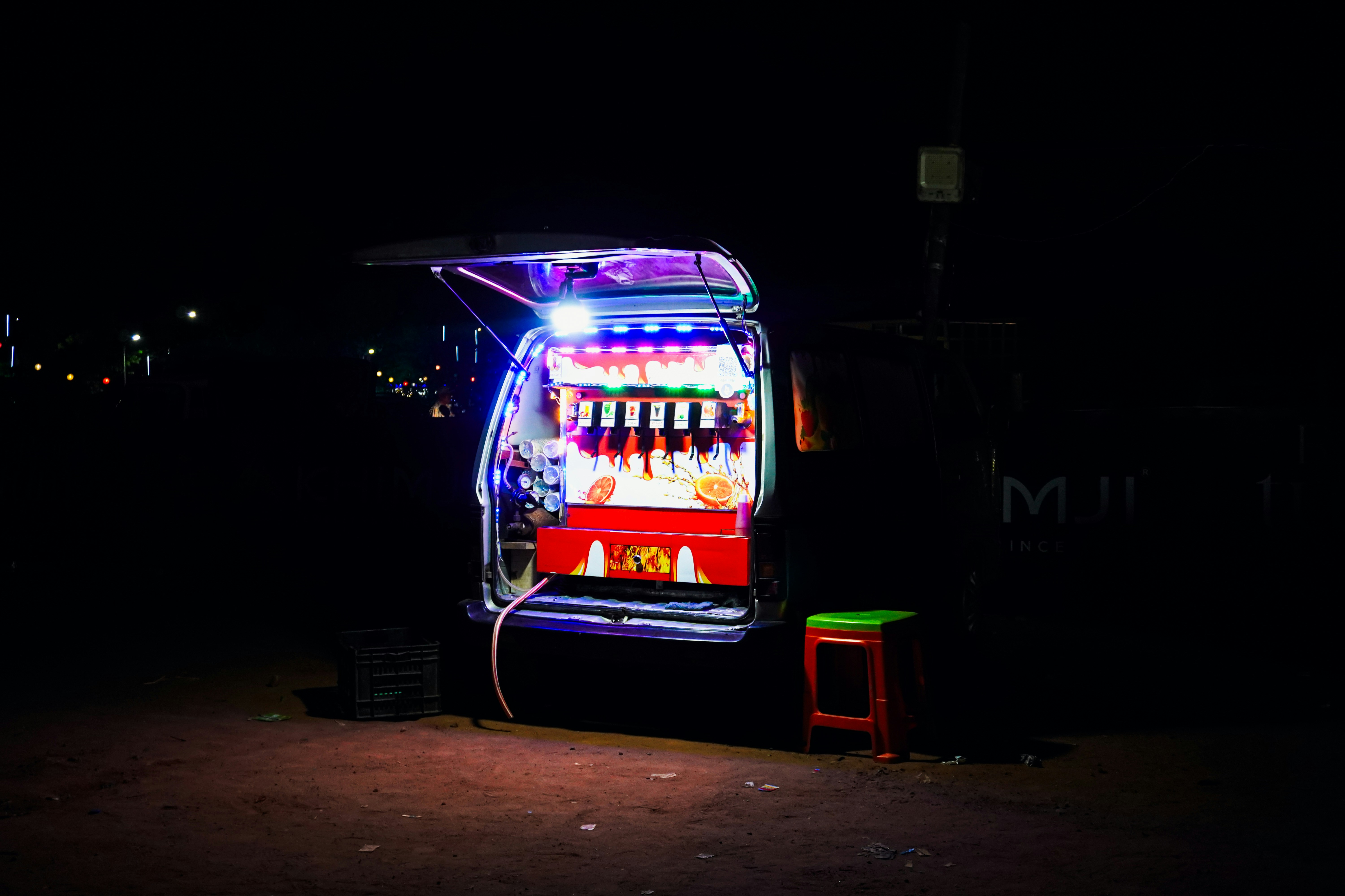 A brightly lit drink dispenser at night