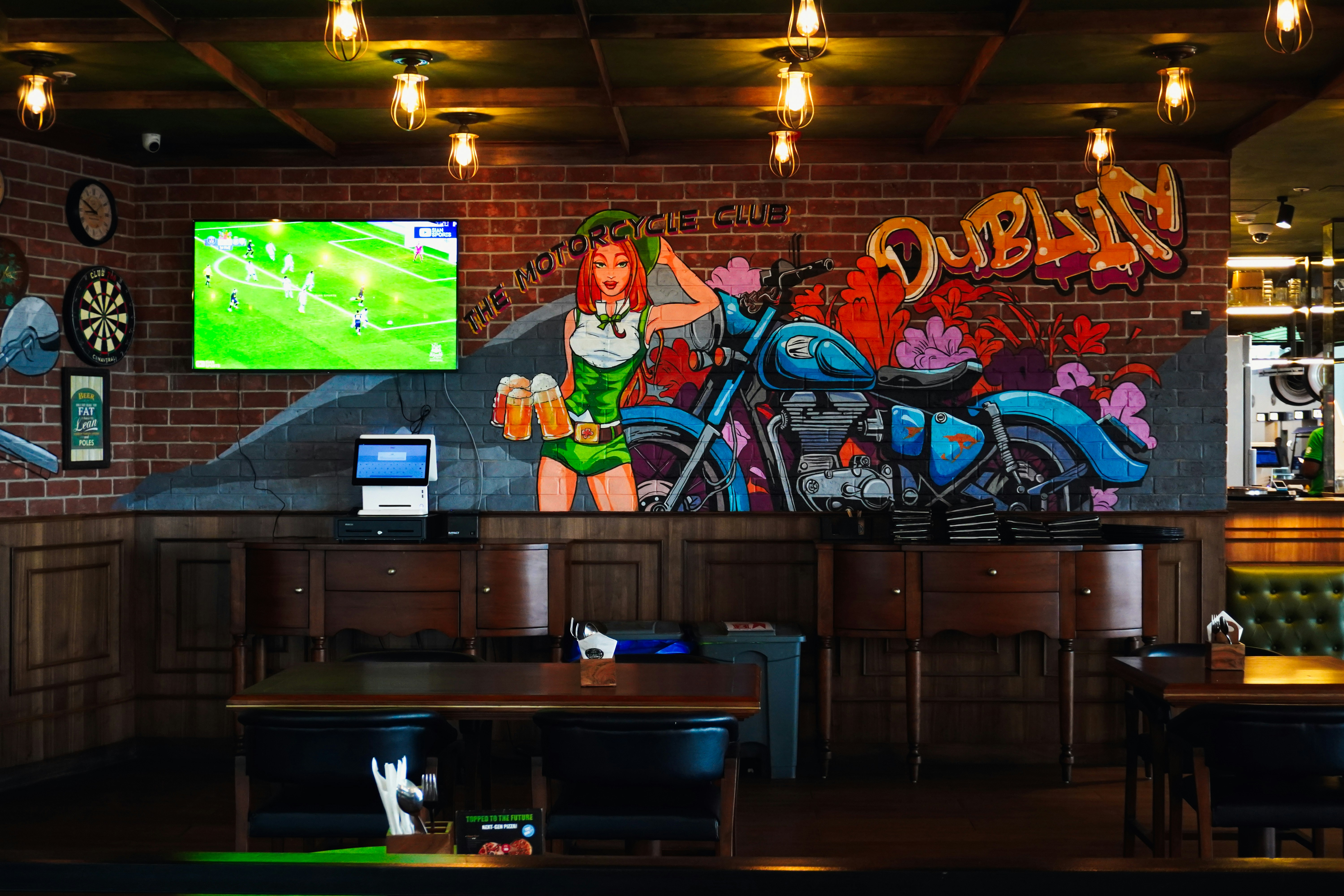 Aficionados viendo fútbol en un bar deportivo durante la noche