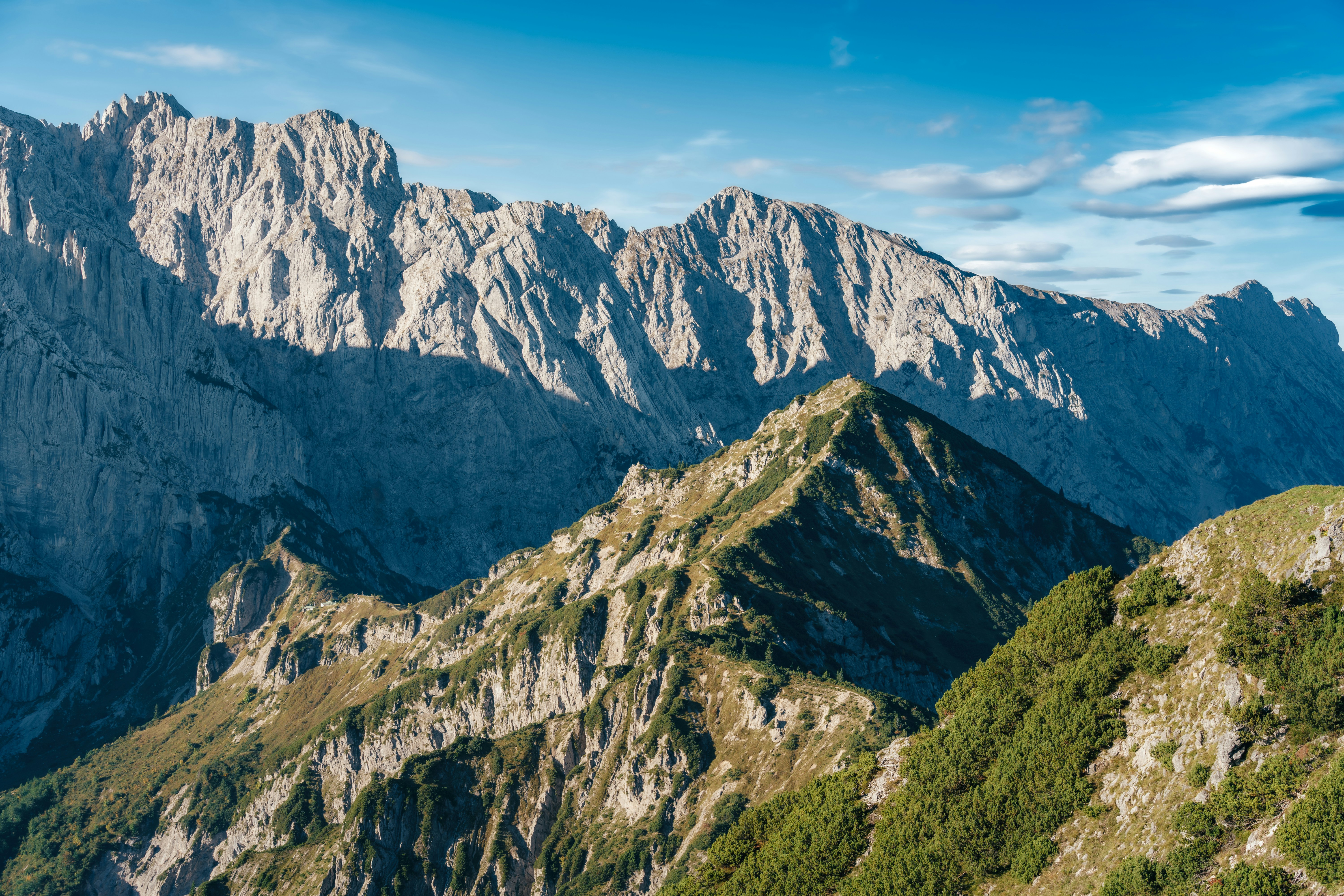 Majestic alpine scenery with snow-capped mountains under a clear blue sky, representing the adventure offered by Alpy Transfers.