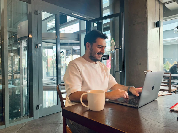 Working on a laptop at a sunny café counter — a typical Route 9 workday