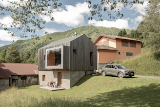 Modern wooden house with a large window and car