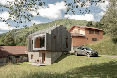 Modern wooden house with a large window and car