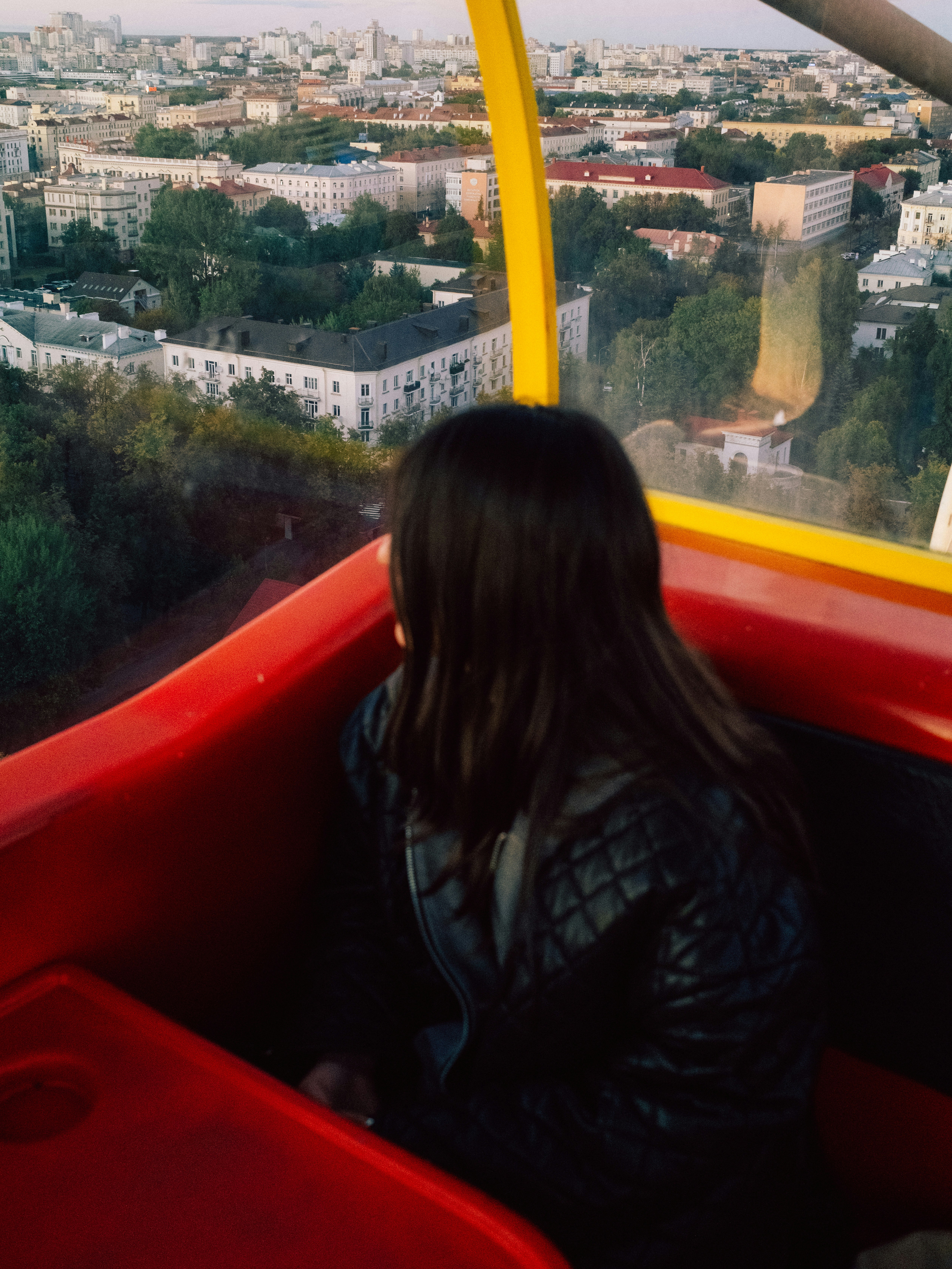 Mujer mirando desde una cabina de rueda de la fortuna.