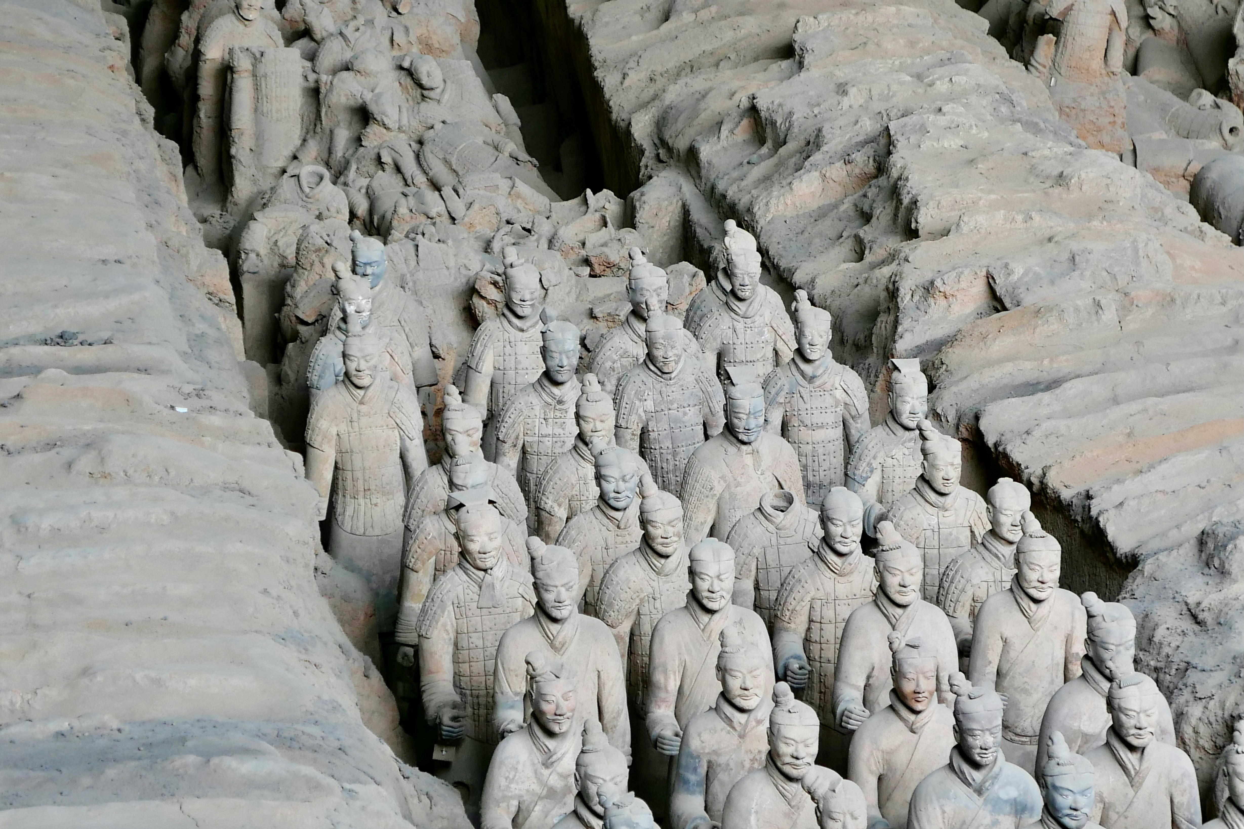 먼지투성이의 발굴된 구덩이에 있는 병마용군 병사들.