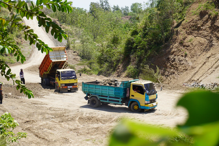 Camions bennes sur route non bitumée de l'arrière-pays