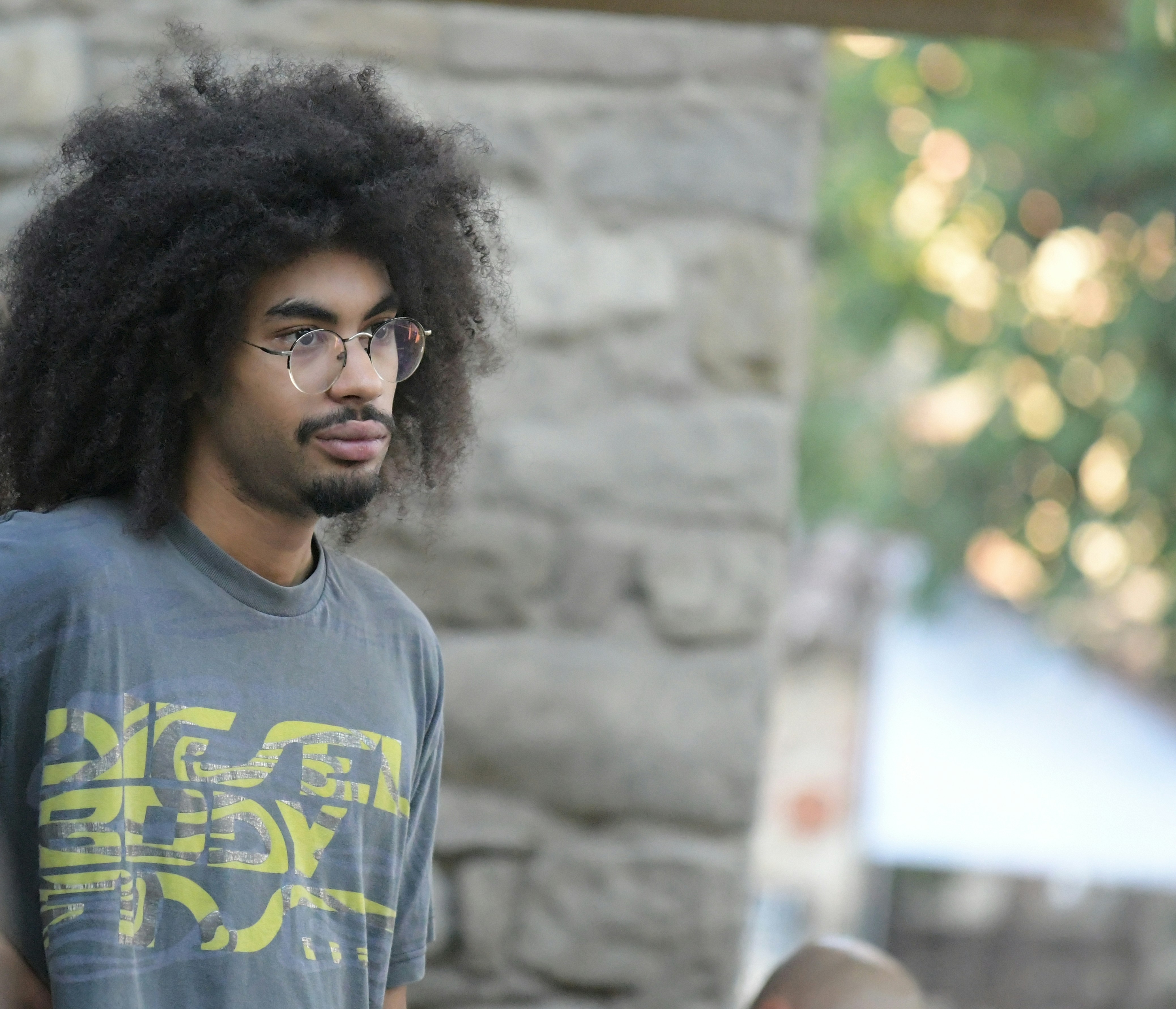 Man with large afro and glasses outdoors