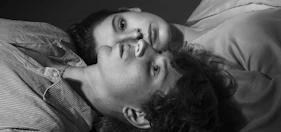 Two young people lying down close together