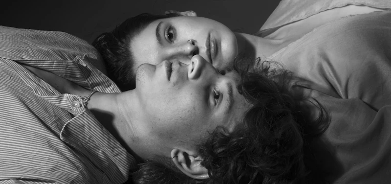 Two young people lying down close together