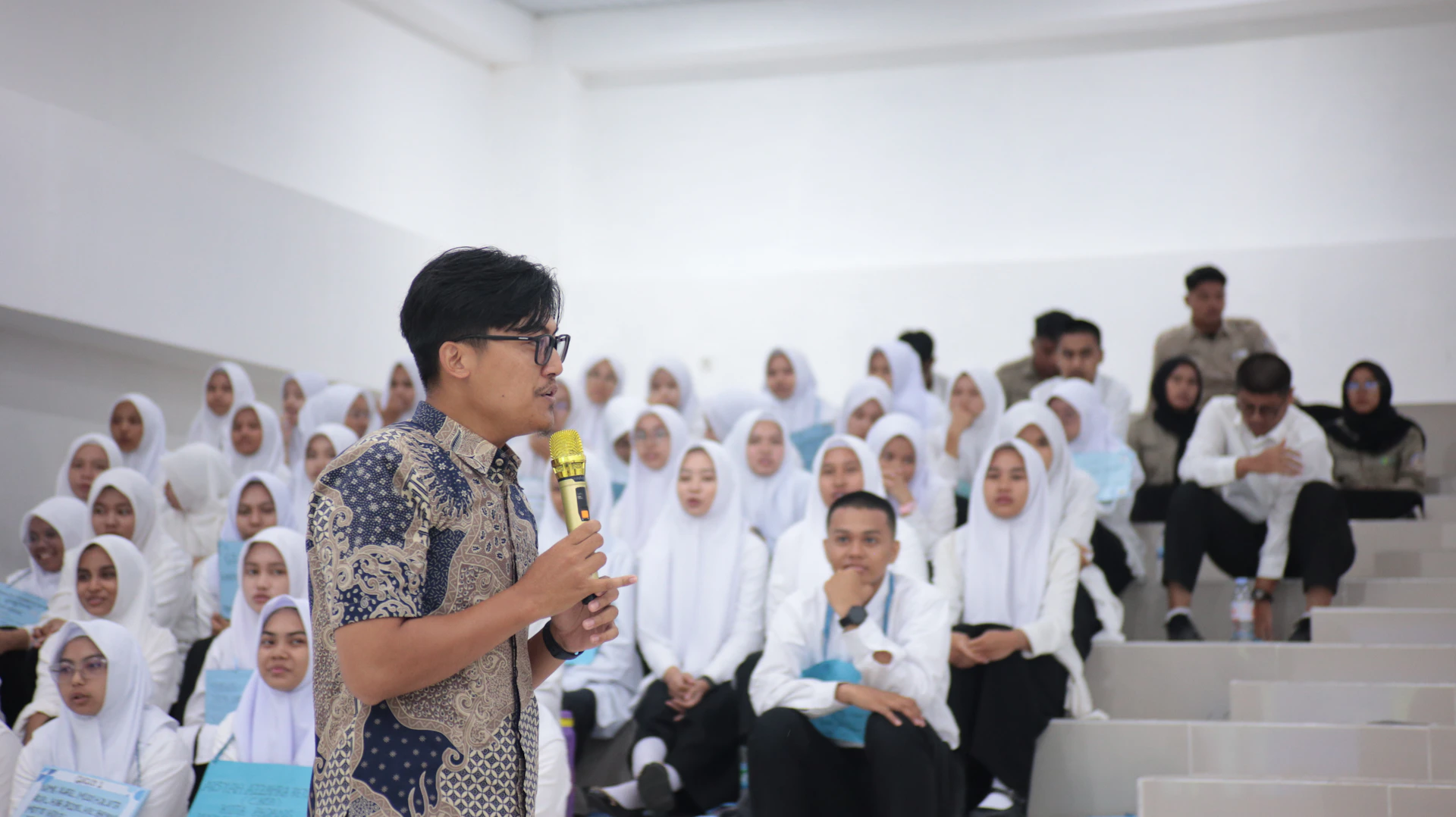 Man speaking to an audience in a lecture hall.
