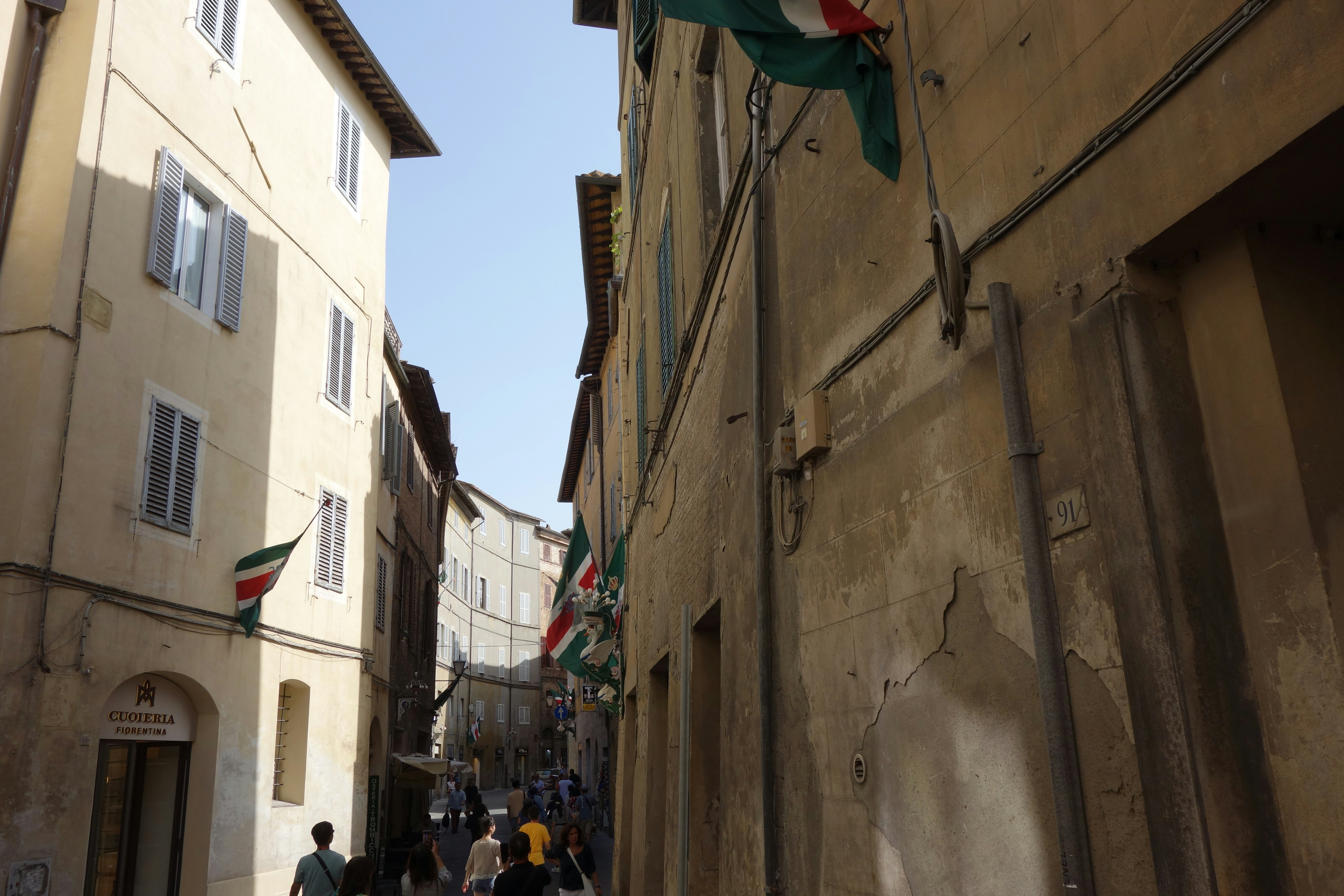 Narrow european street with flags and buildings