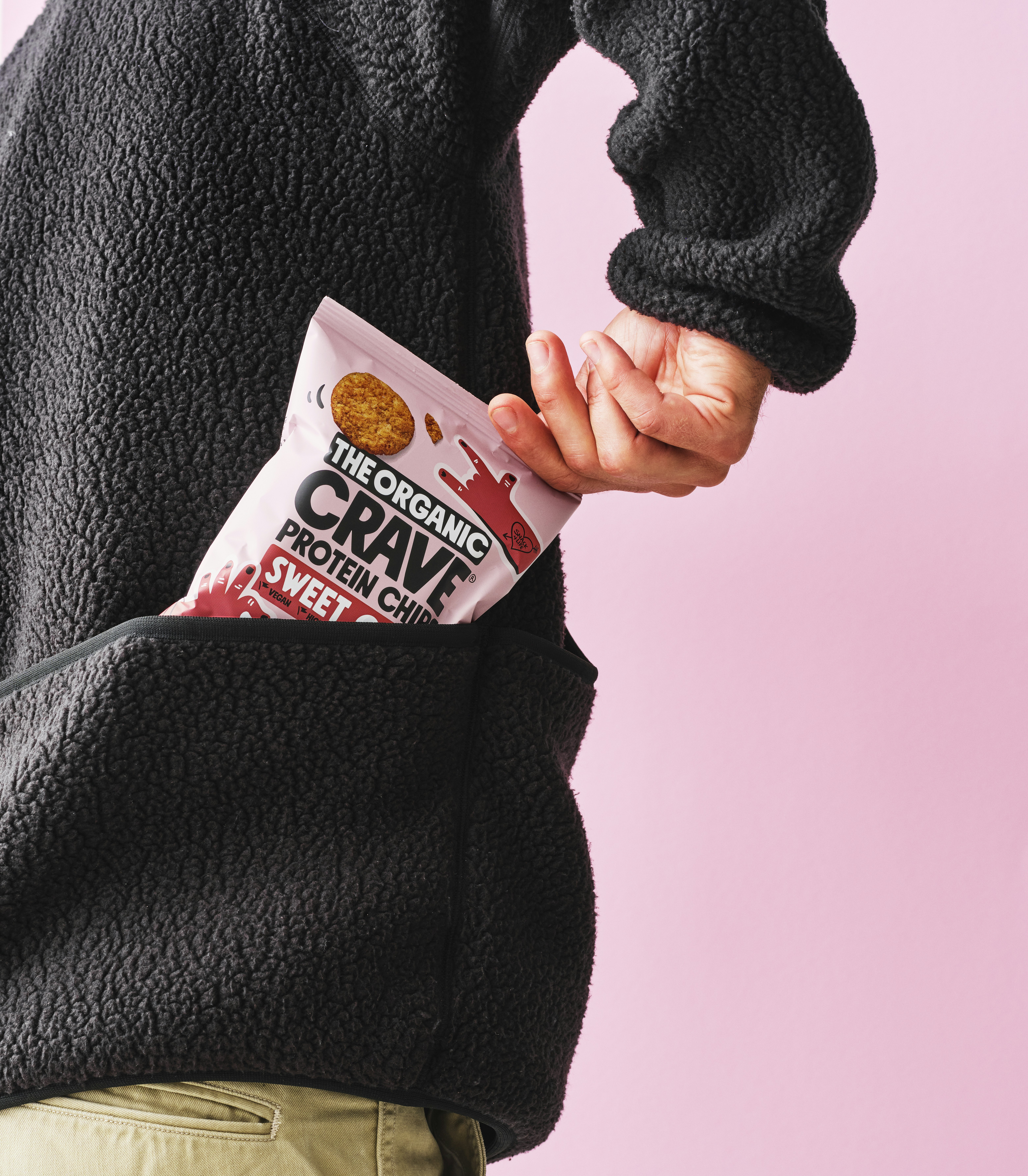 Hand placing bag of protein chips into pocket