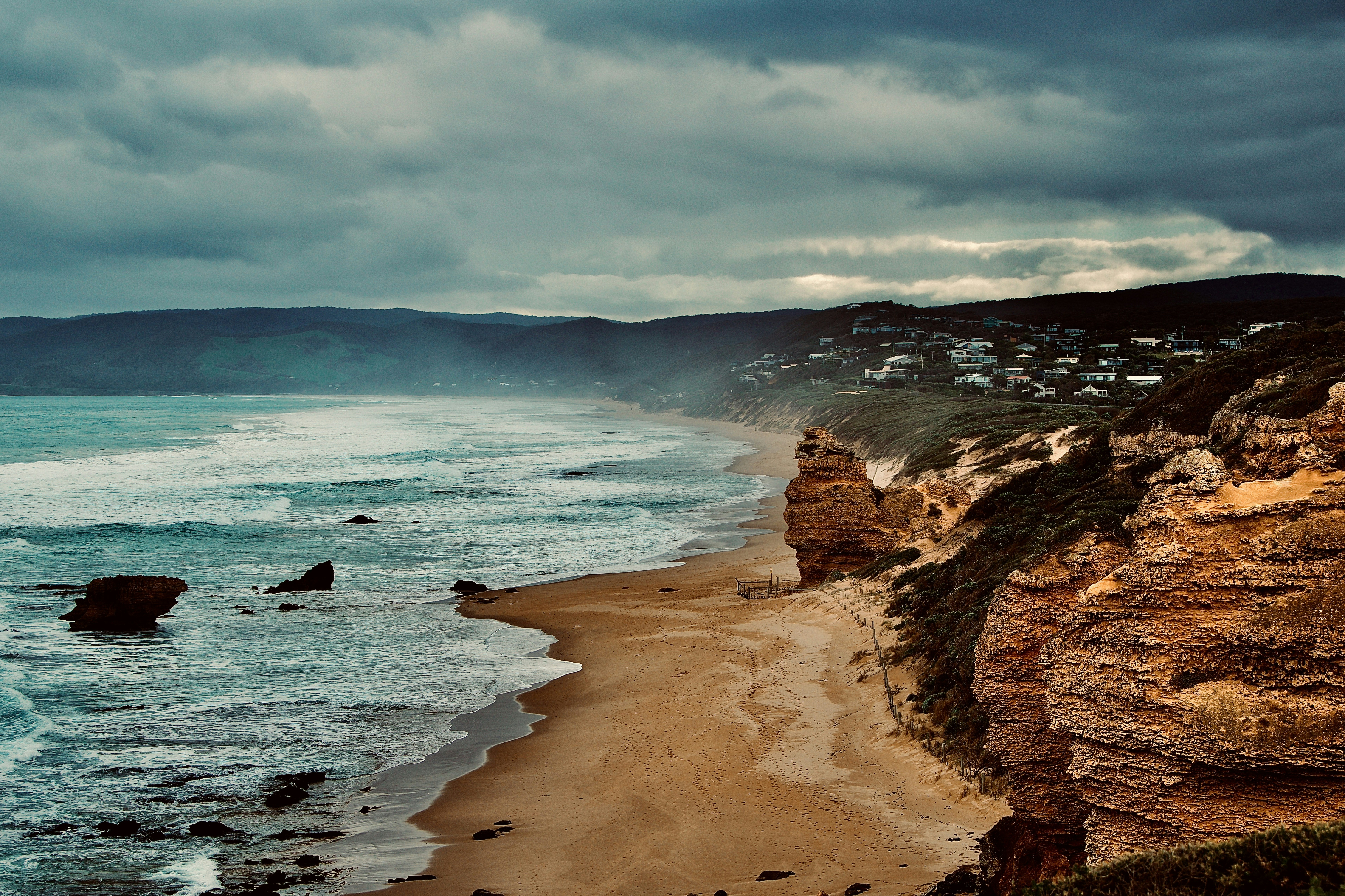 모래 해변과 파도가 있는 울퉁불퉁한 해안선.