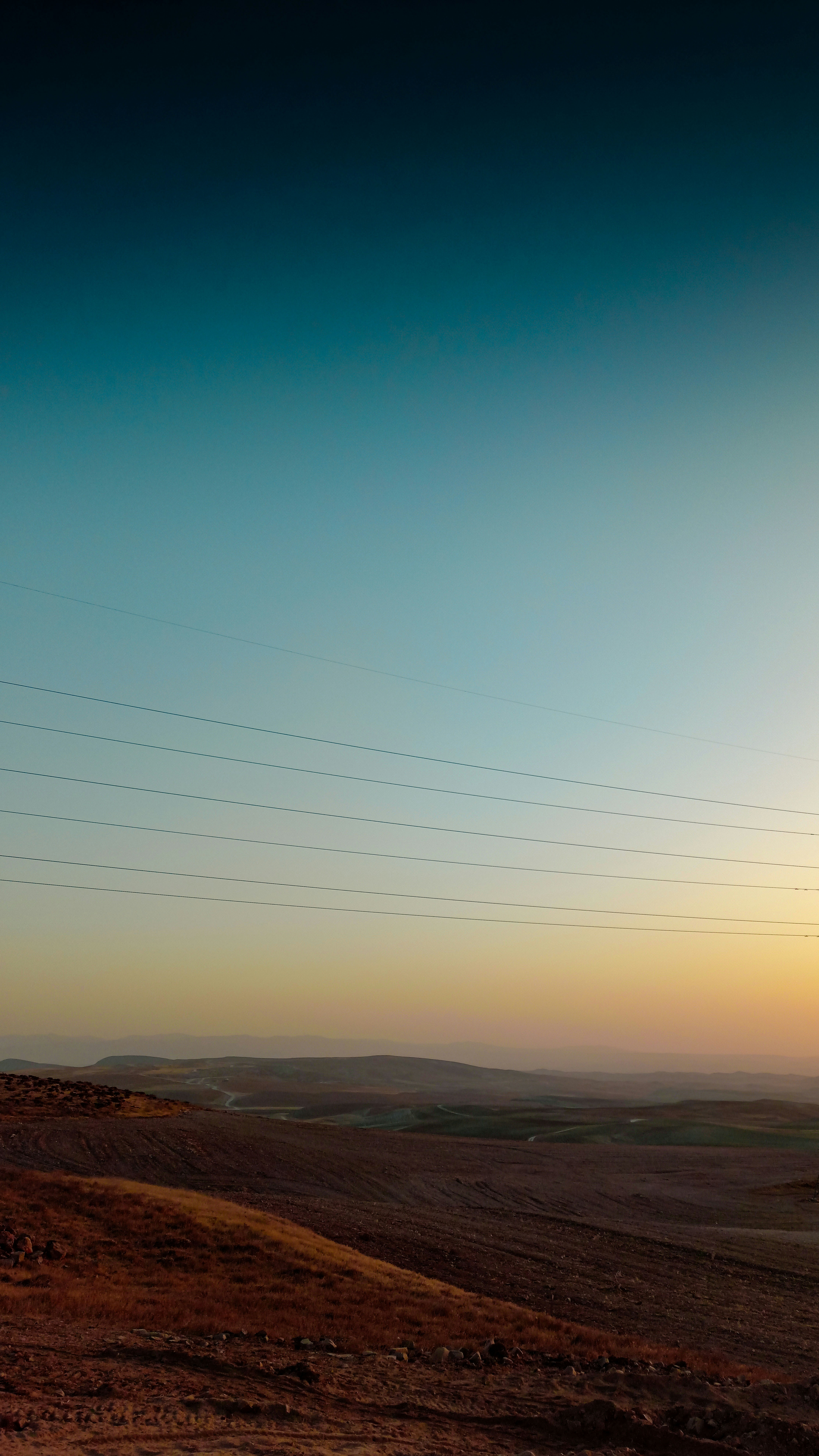 Rolling hills under a gradient sky at sunset