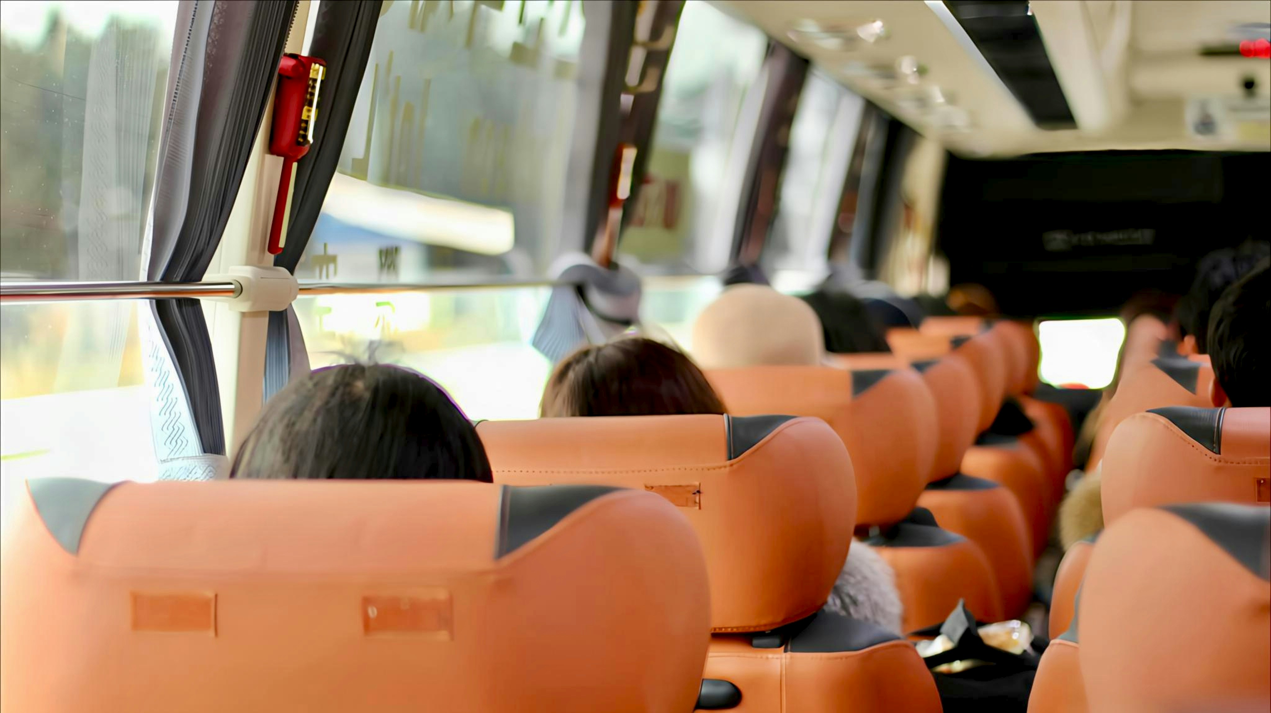 Passengers seated inside a bus looking out windows.