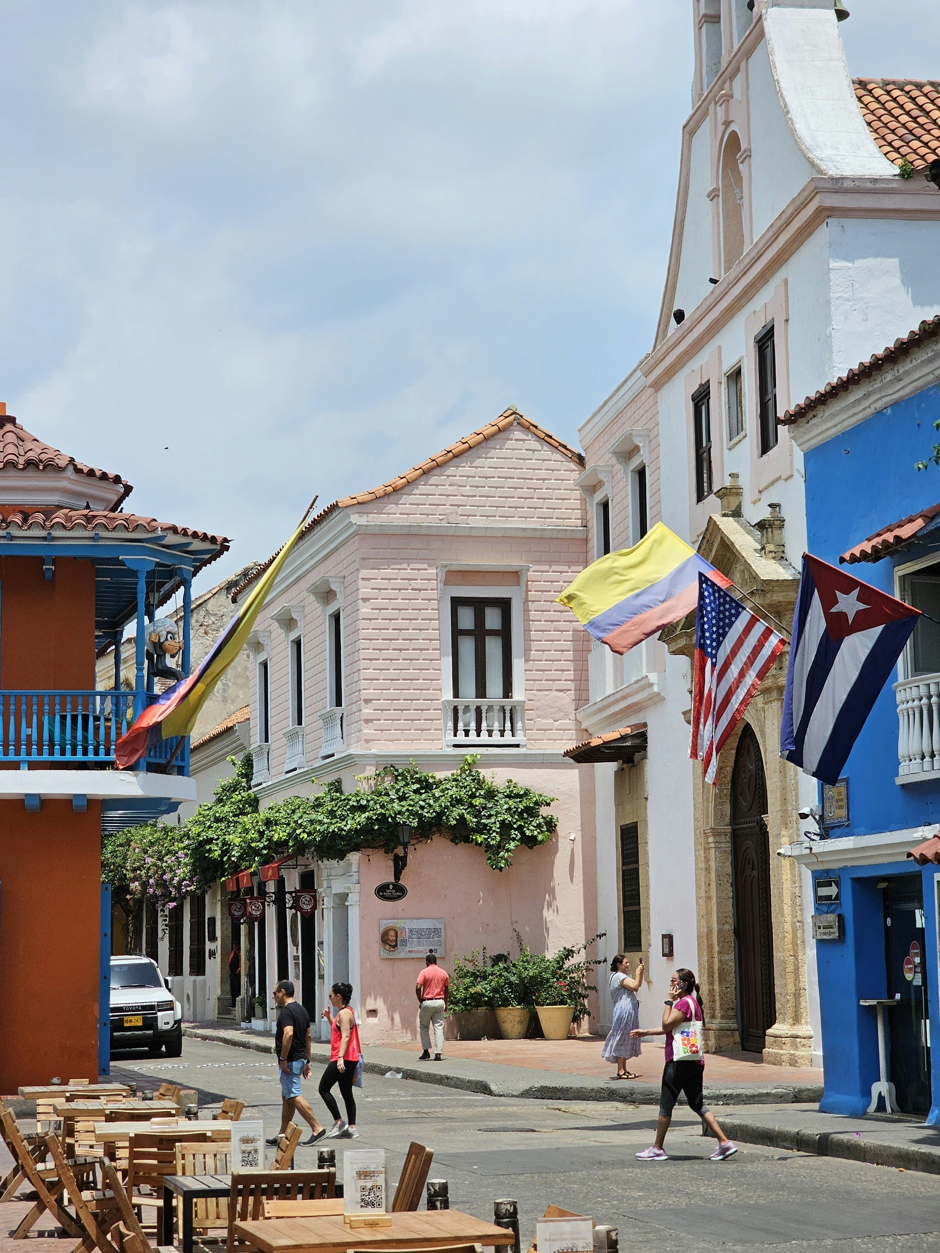 Colorful buildings with flags on a sunny street.