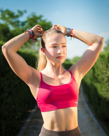 Young woman tying her hair back outdoors