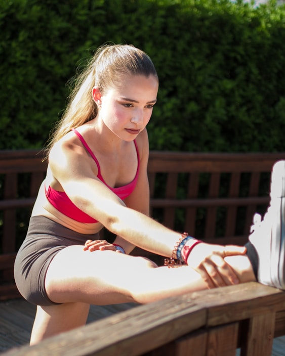 Young woman stretching her leg outdoors.