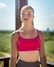 Young woman in pink sports bra outdoors