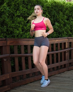 Young woman jogging on a wooden path outdoors.