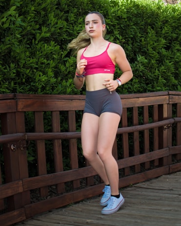 Young woman jogging on a wooden path outdoors.