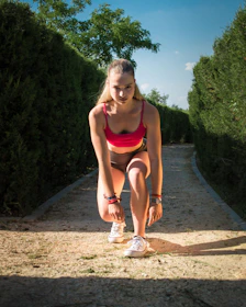 Young woman in athletic wear tying shoelaces before race.