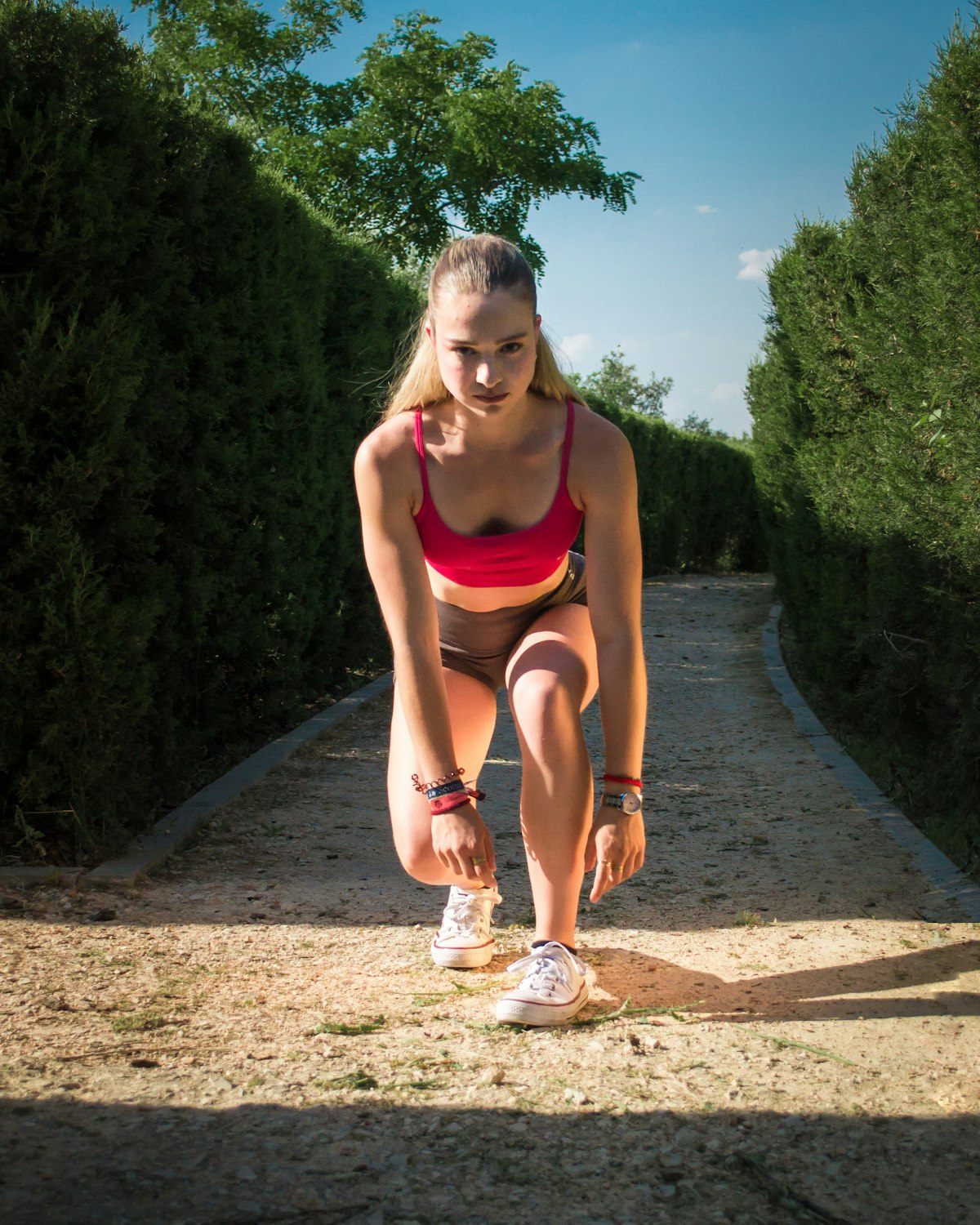 Young woman in athletic wear tying shoelaces before a race