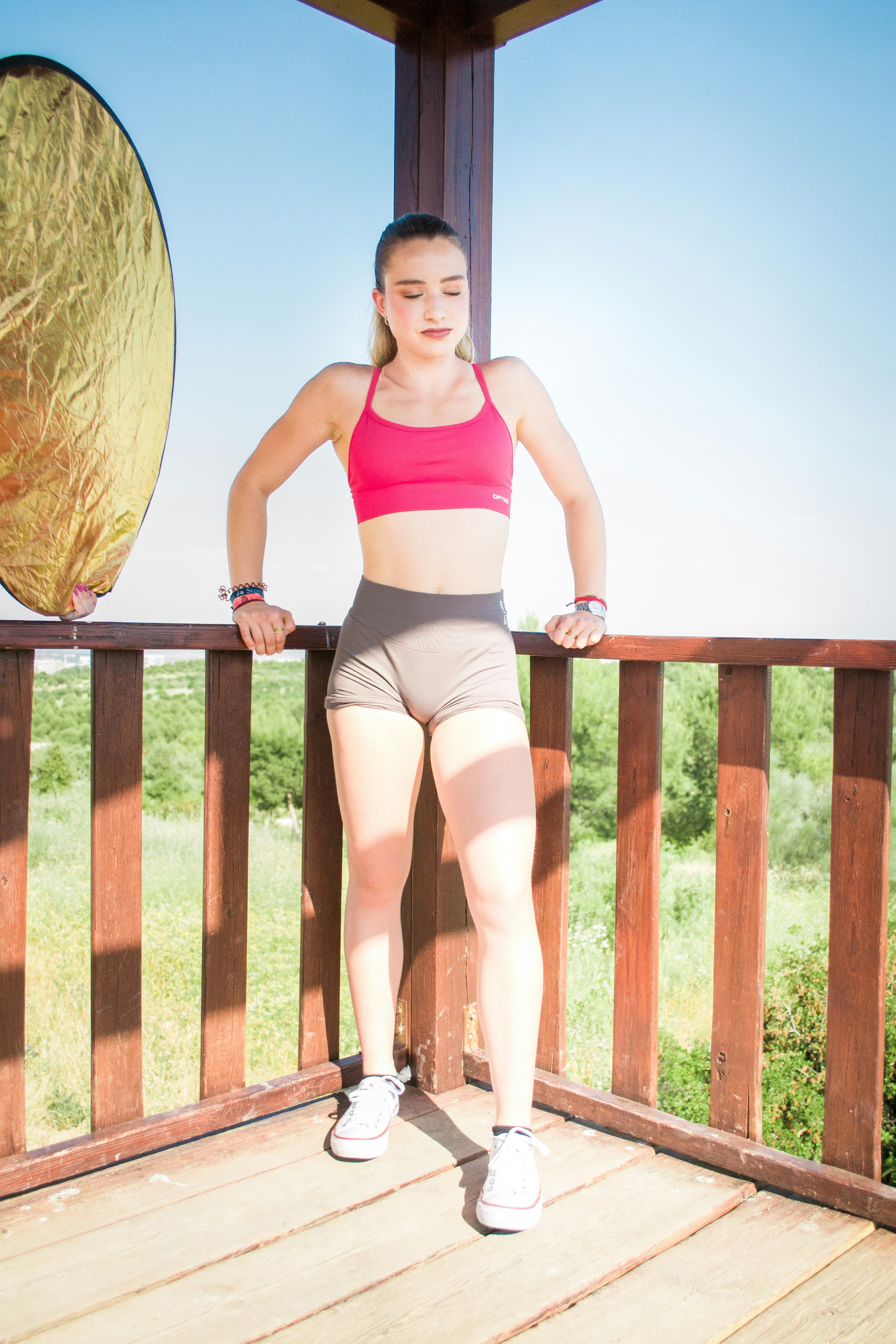 Young woman in athletic wear on wooden platform.