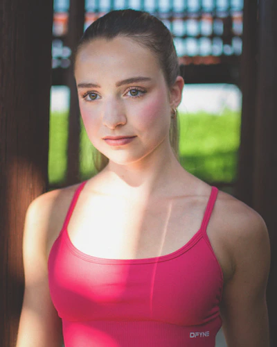 Young woman with blonde ponytail in pink top