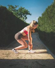 Mulher com roupa esportiva na linha de largada pronta para corrida, fitness e emagrecimento.