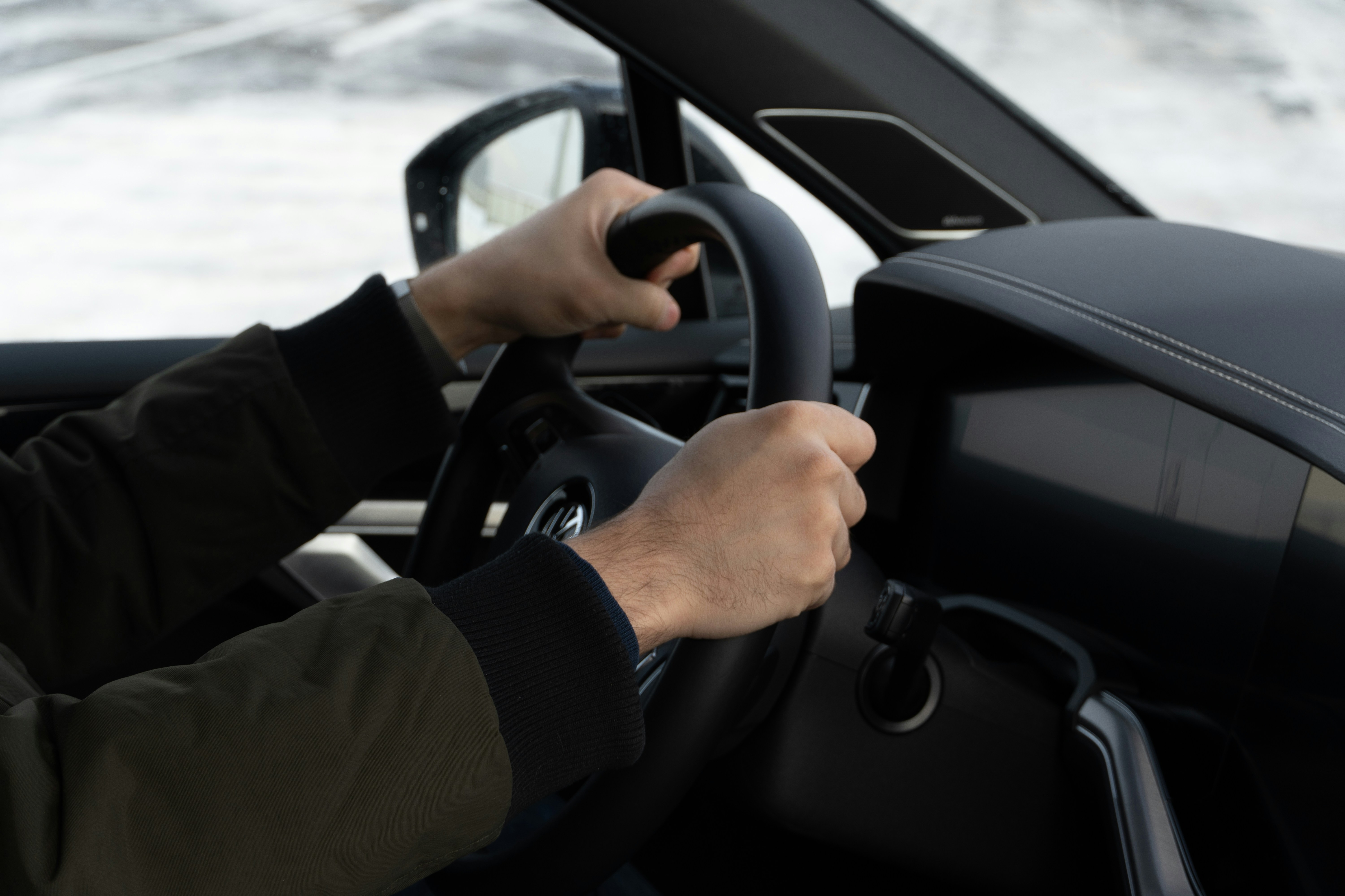 Hands on steering wheel driving a car