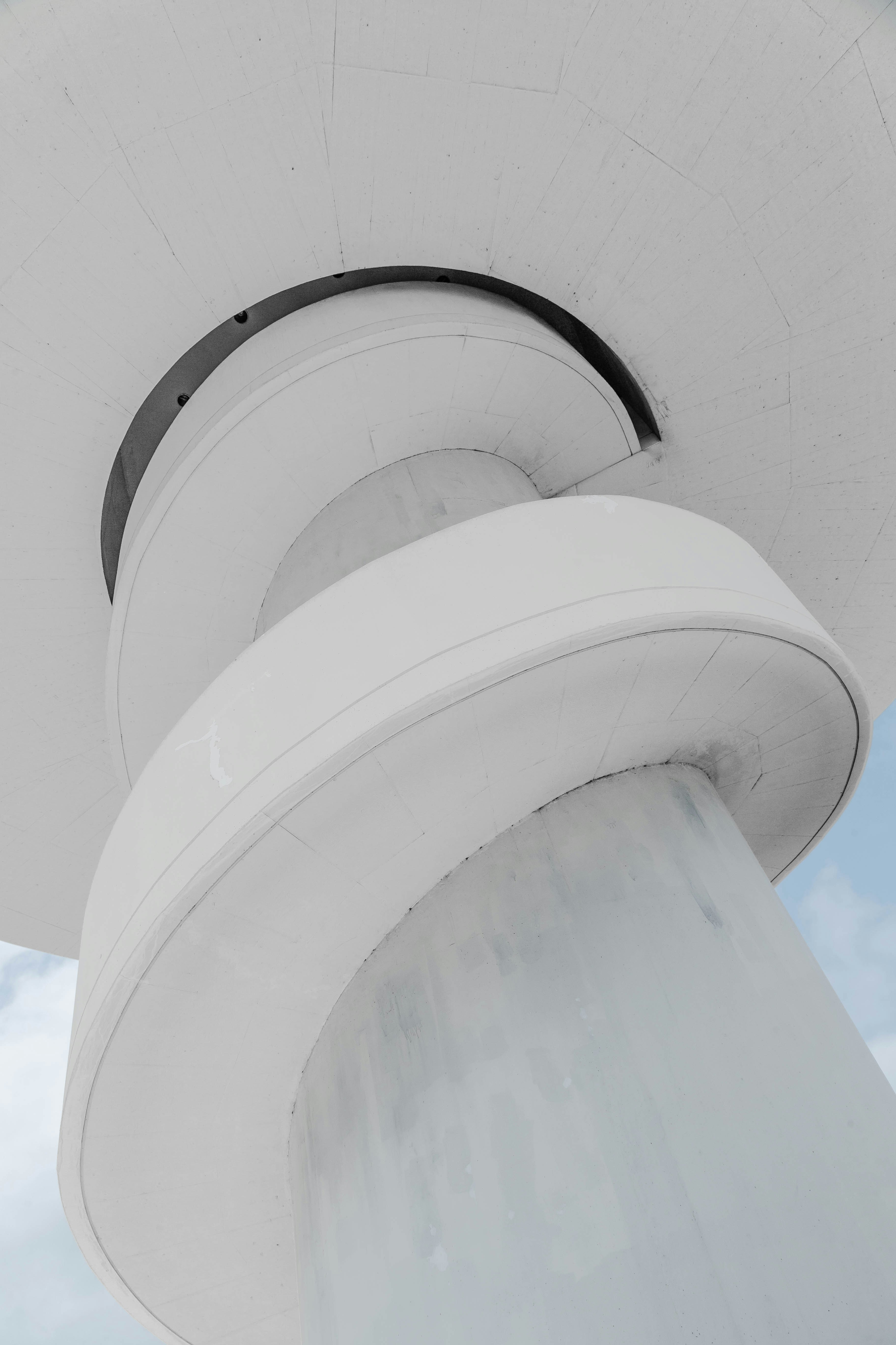 Modern white spiral staircase against blue sky