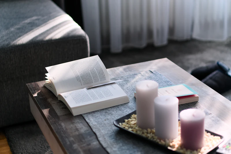 An open book with candles on a wooden table — a calm, quiet setting