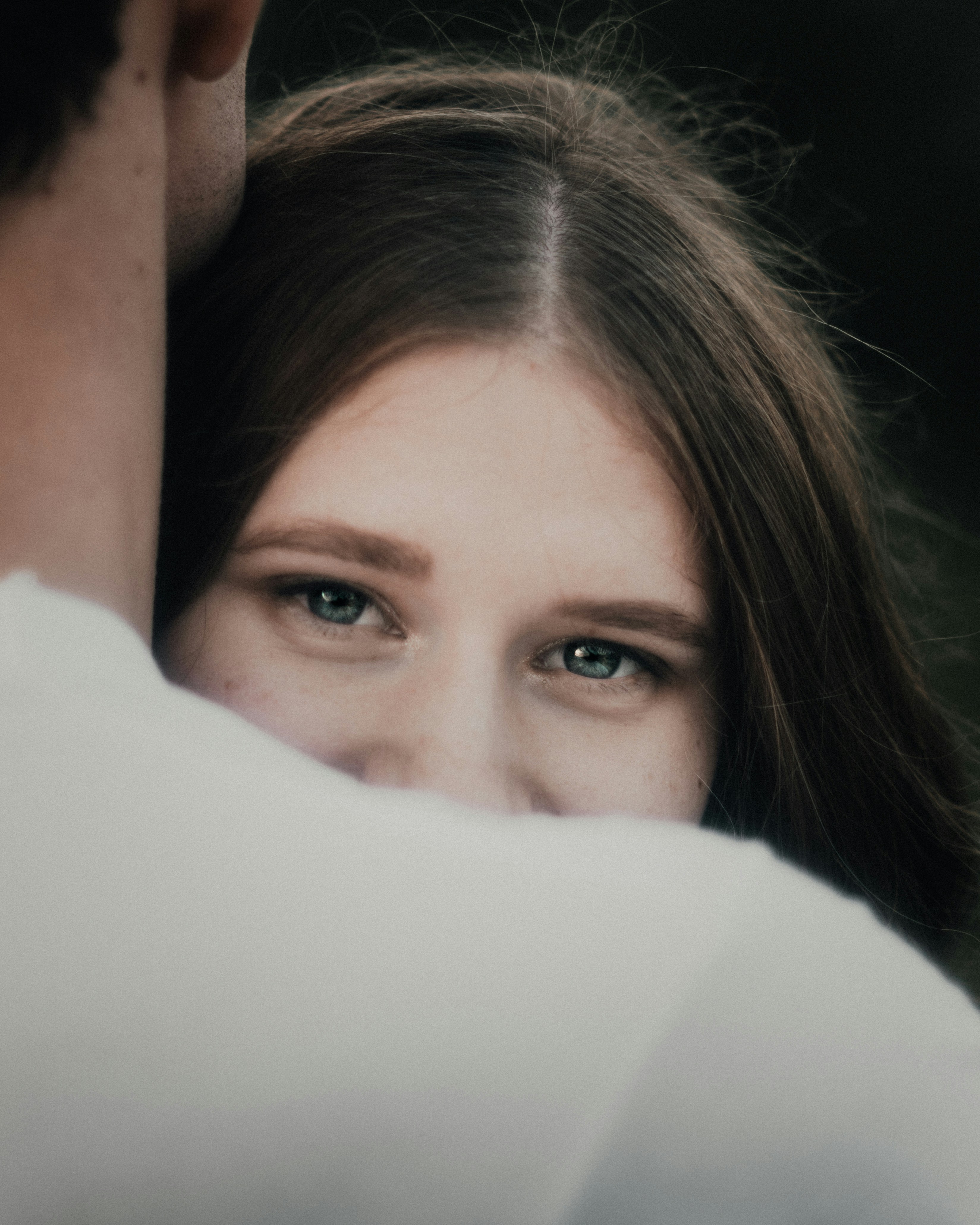 Woman peeking over man's shoulder