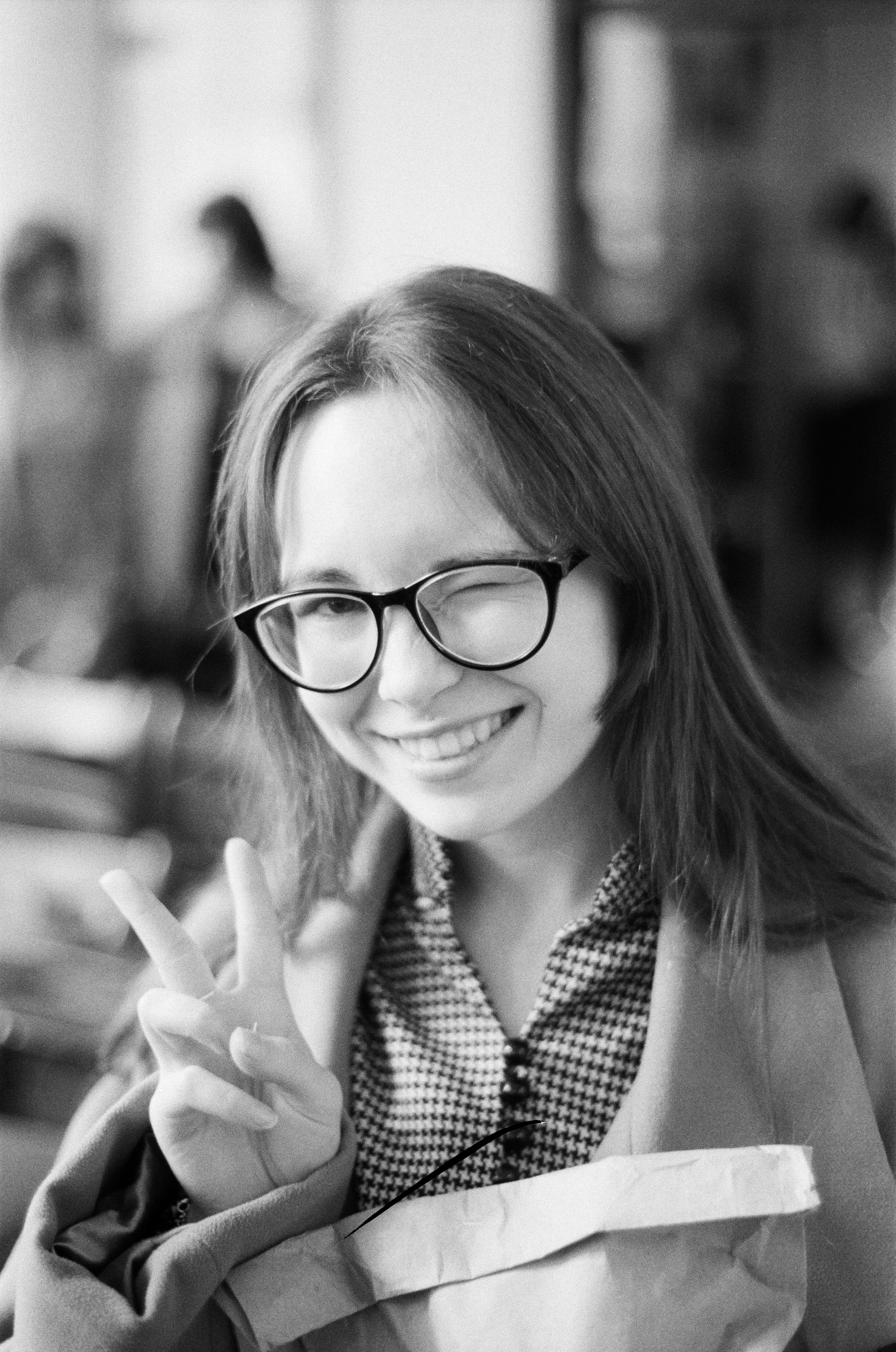 Young woman winks and flashes peace sign