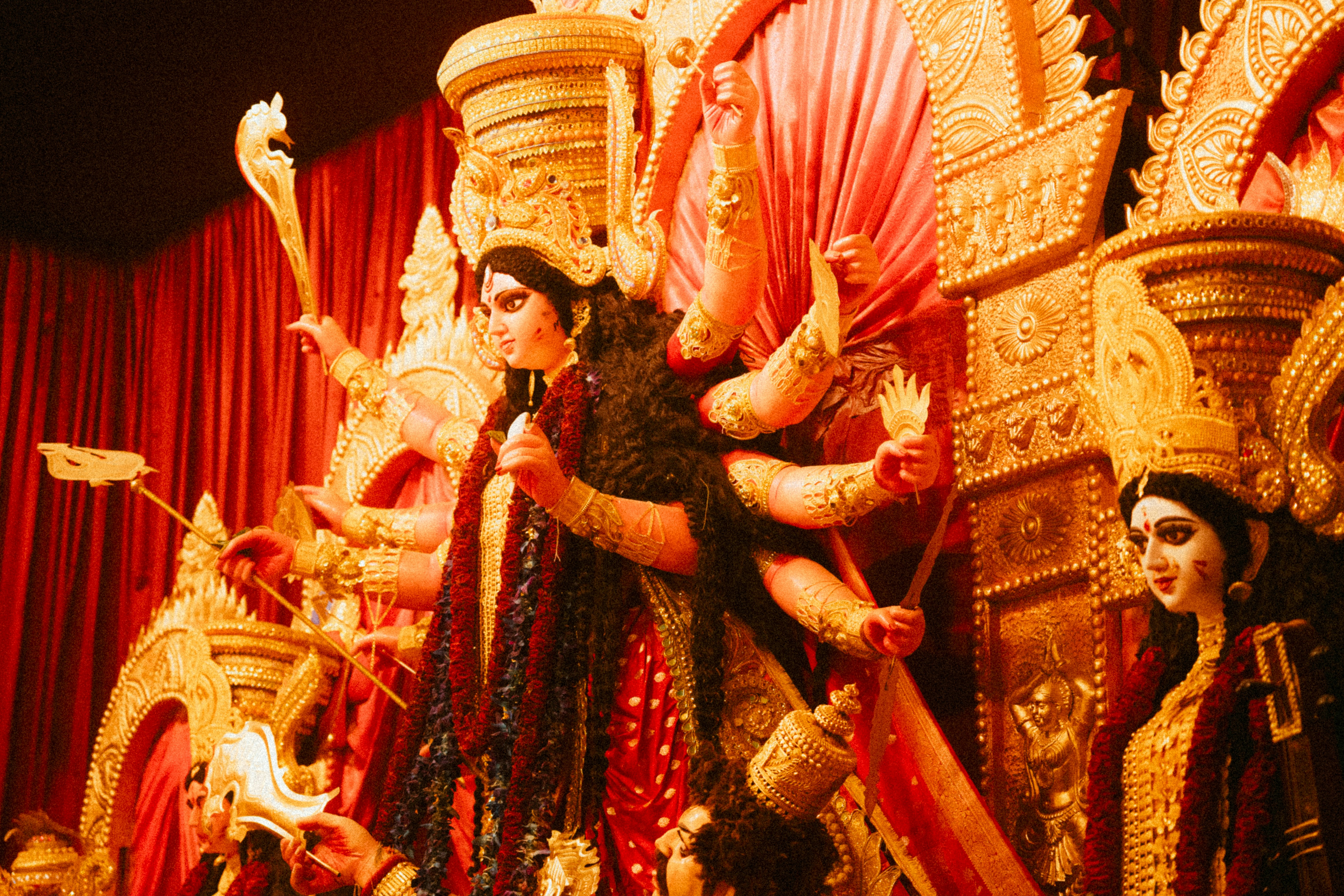 Elaborate durga puja idol with multiple arms and deities.