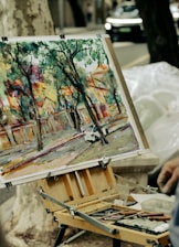 Artist paints a vibrant street scene outdoors