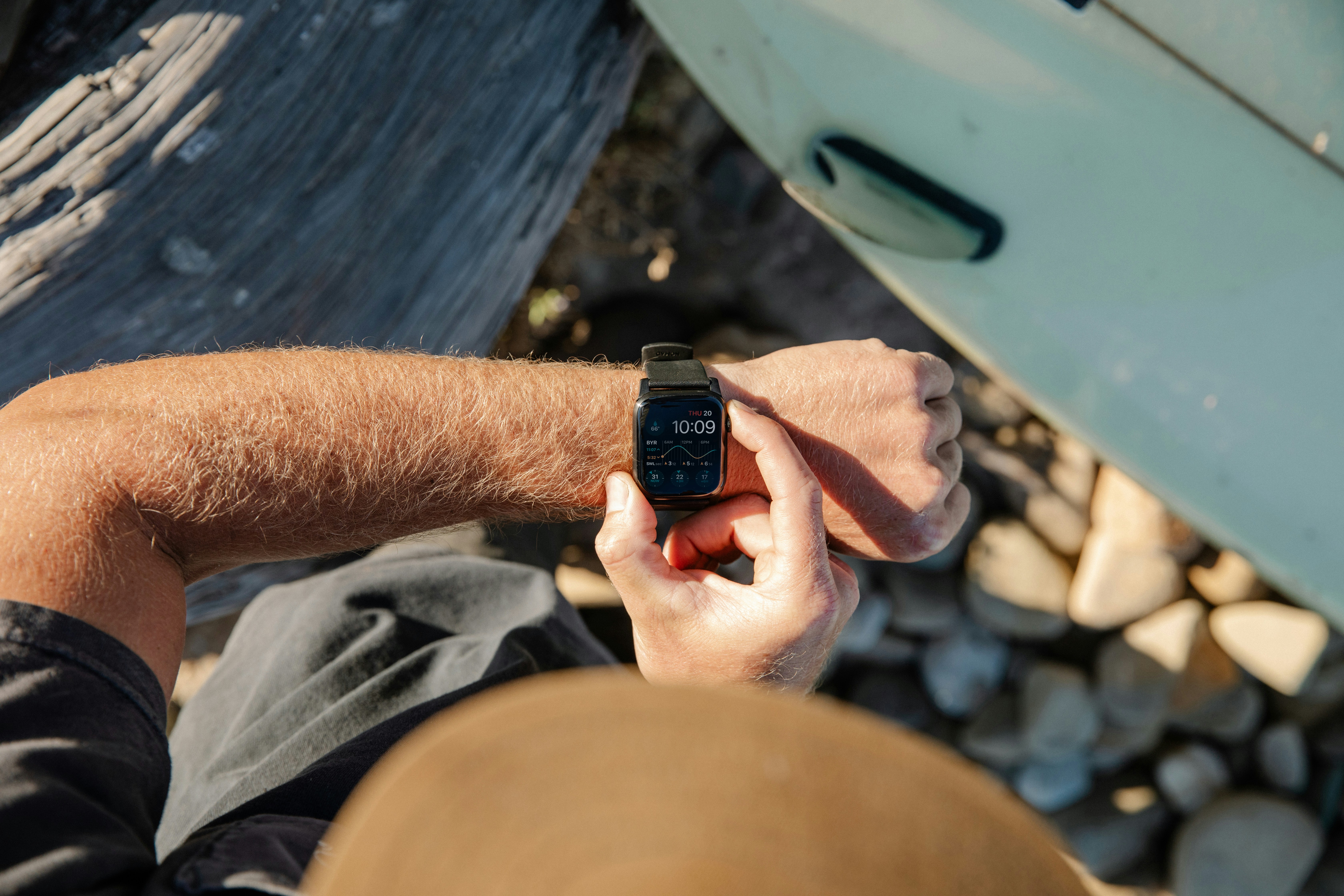 person checking biometric health stats on titanium smartwatch outdoors
