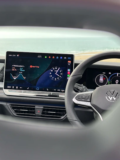 Modern car dashboard with digital display and steering wheel.