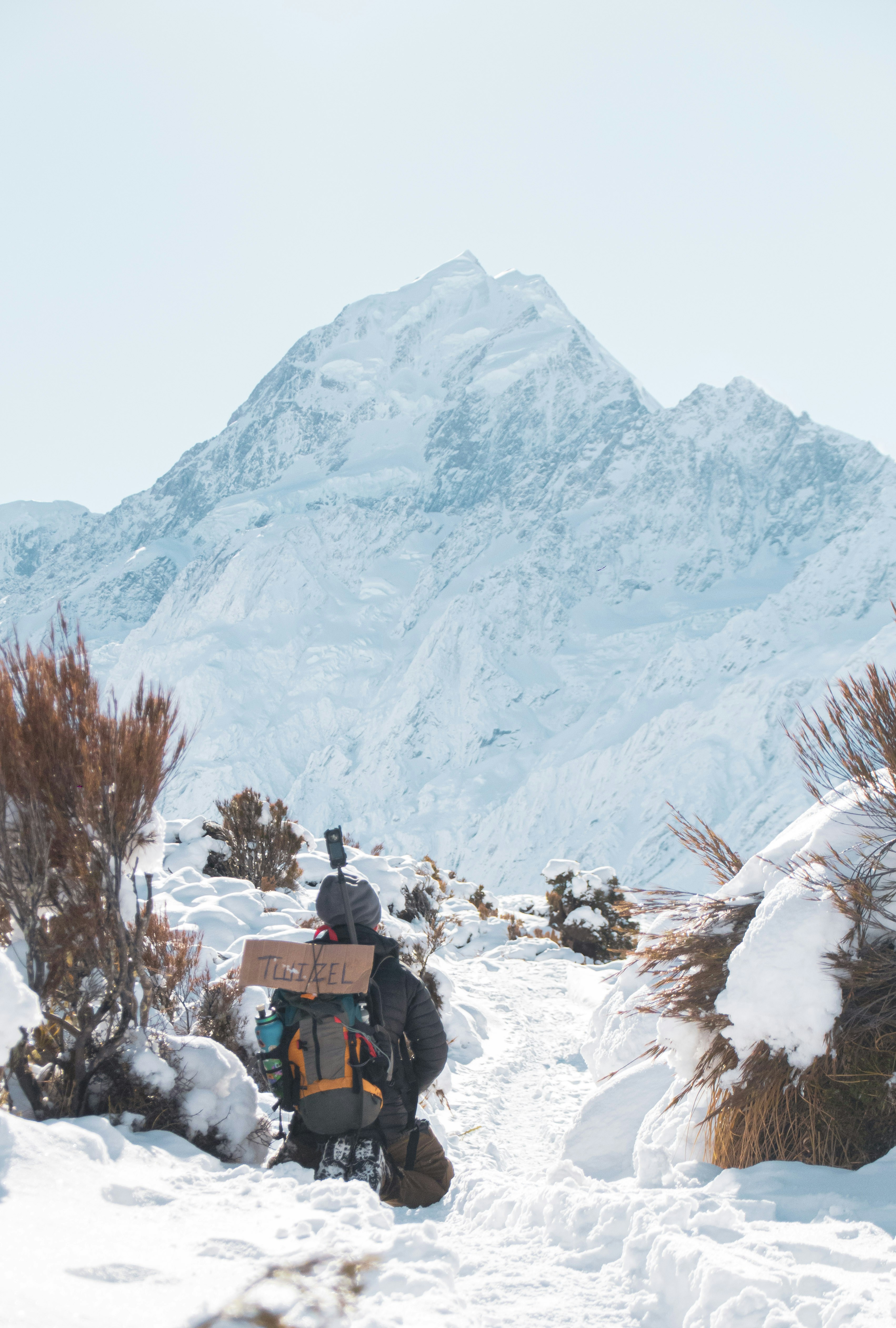 Backpacker mit Ausrüstung auf verschneitem Bergpfad