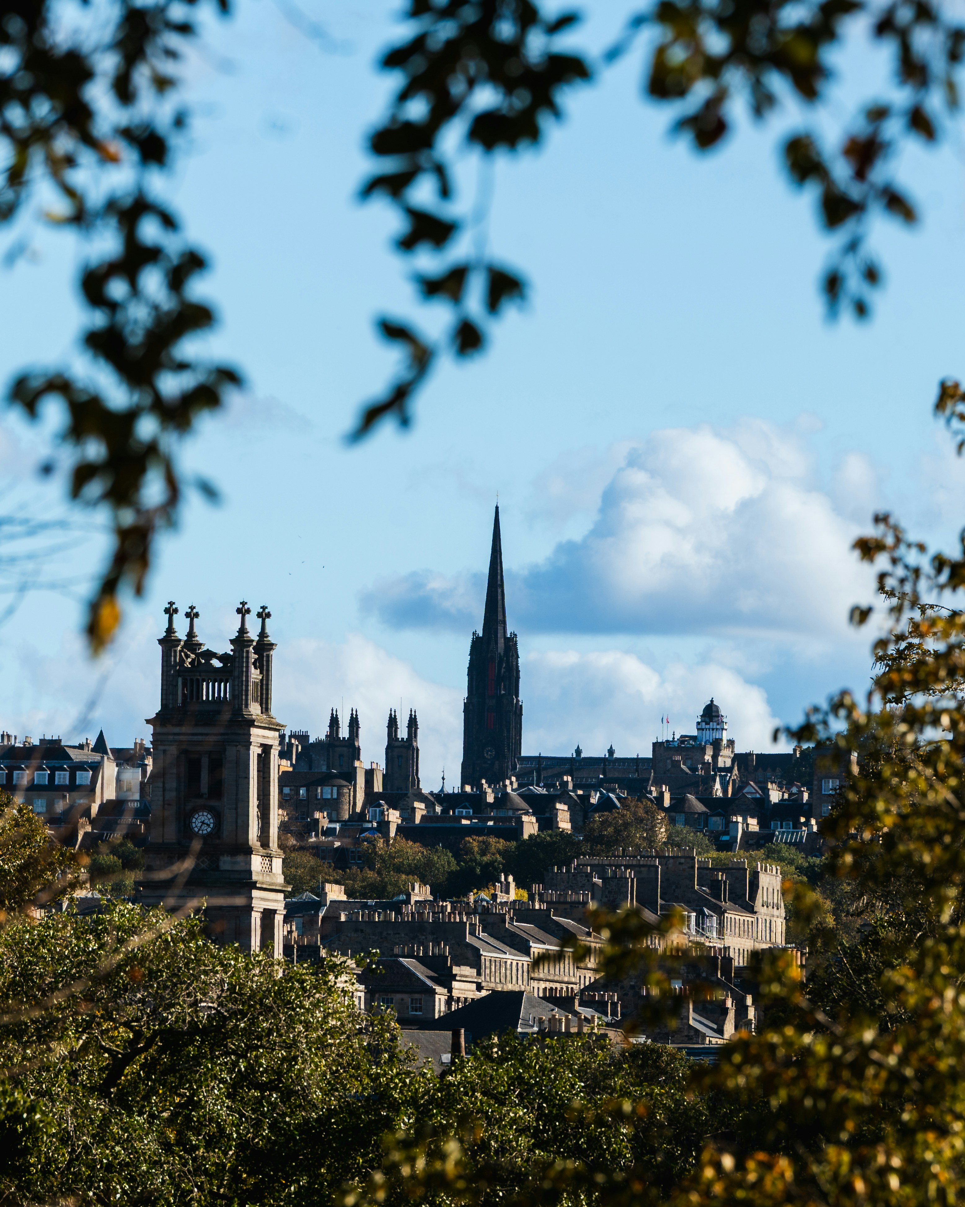 Historic city skyline seen through autumn leaves