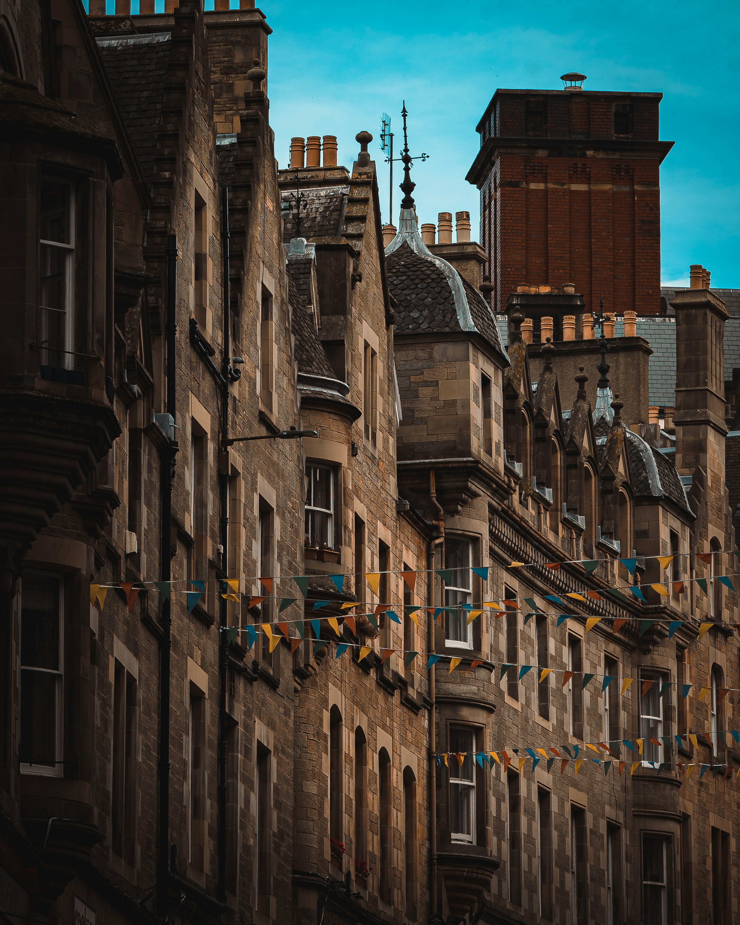Old stone buildings with colorful flags under blue sky