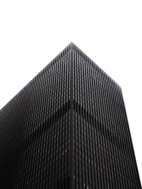 Modern dark skyscraper against a white sky