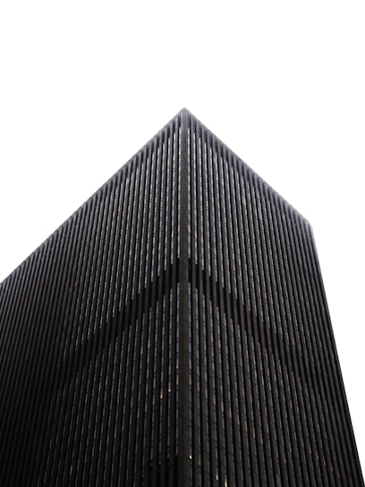 Modern dark skyscraper against a white sky