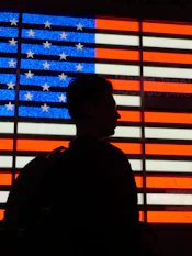 Silhouette of person against illuminated american flag
