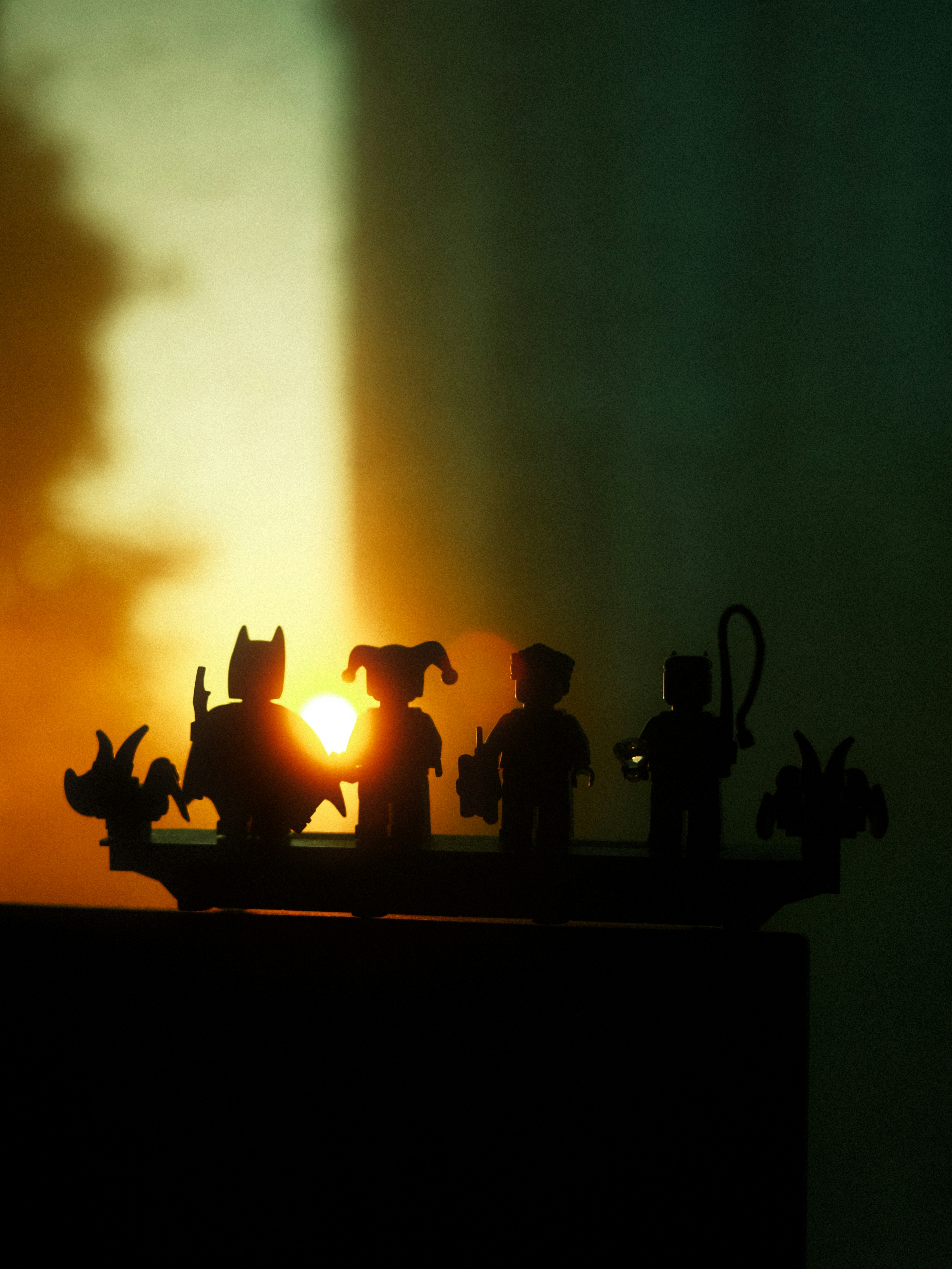 Silhouettes of lego figures against a sunset.