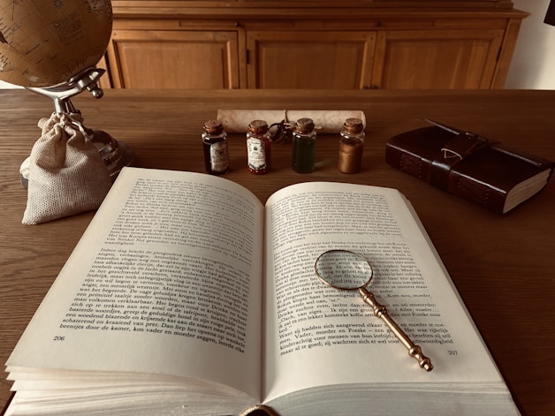 Open book with magnifying glass on desk