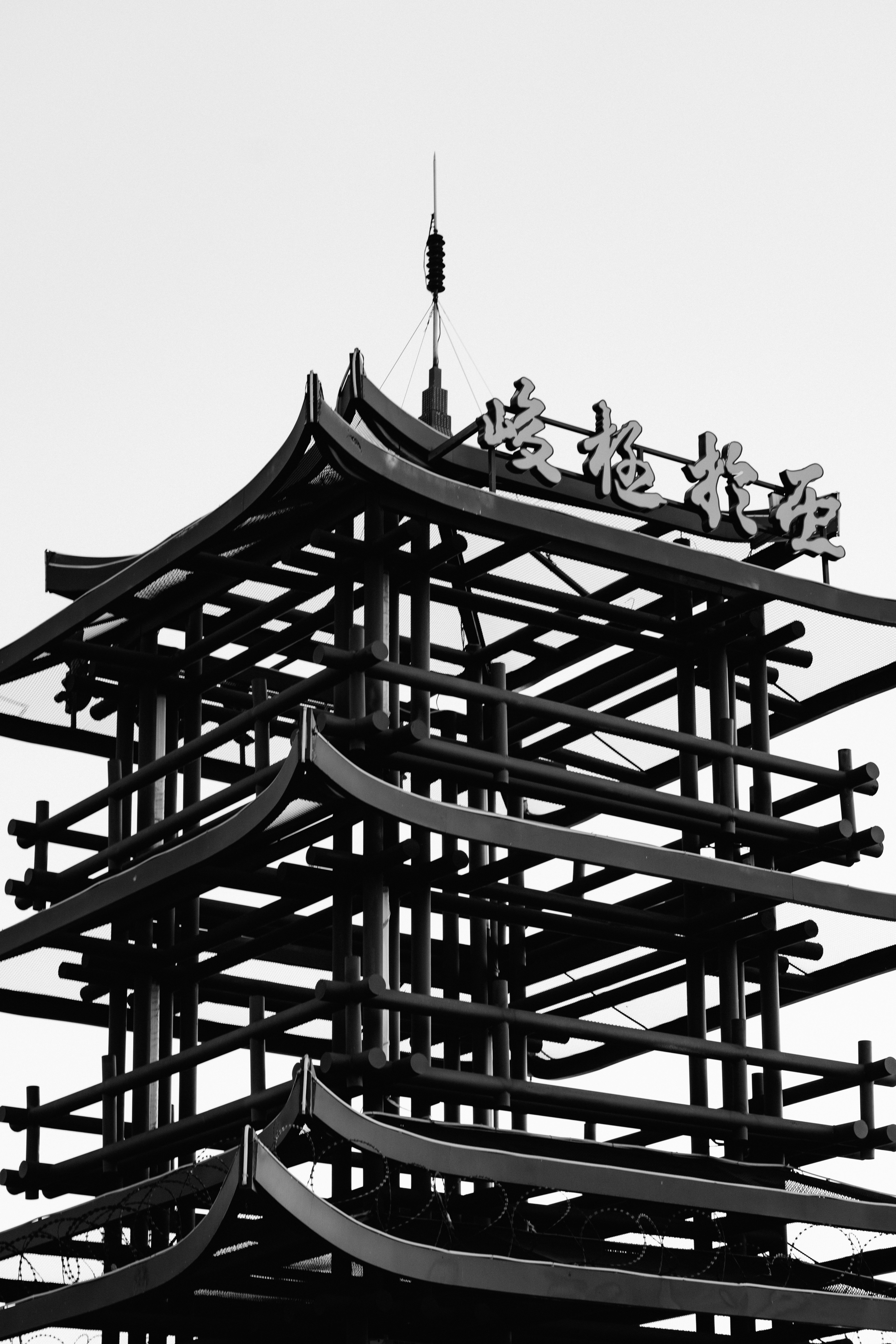 Modern pagoda structure with asian characters on top.